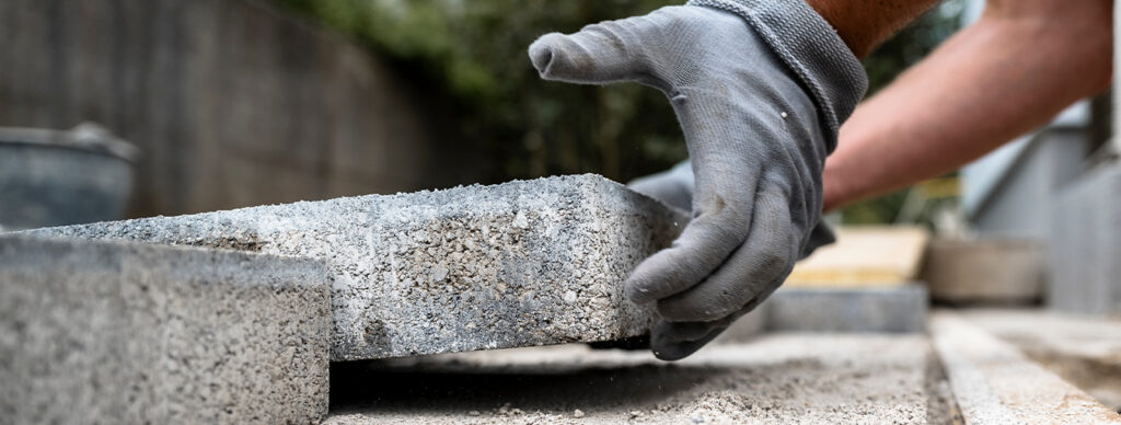 a man placing a concrete paver